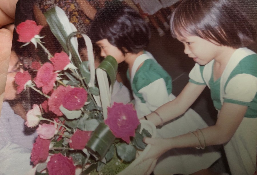 Li-Chuen presenting flowers to the General who is visiting her school (1977)