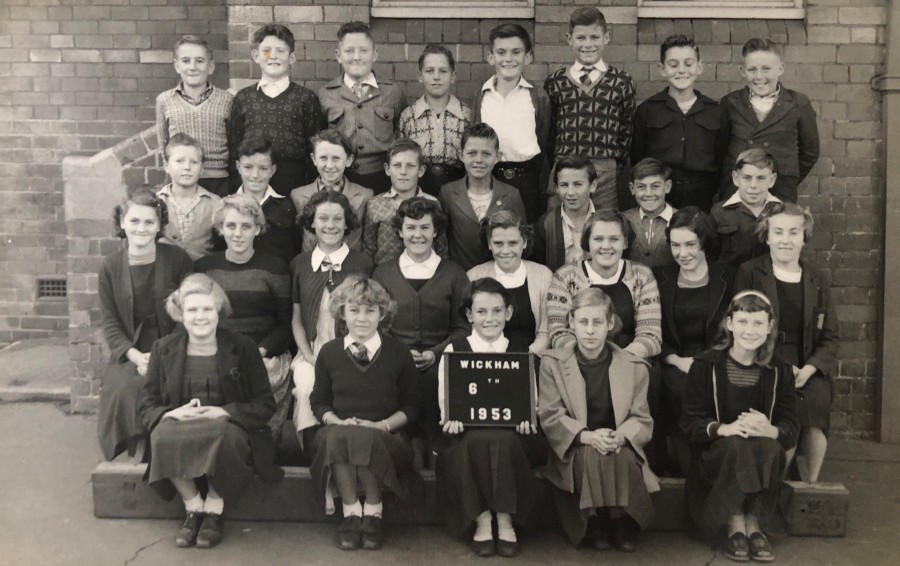 Grade 6, Wickham Primary School (1953). Back row from left: Frank Powell, Gordon Sessions, Alan Cavanough, John Fordham, Ron Maguire, Winston Loads, Doug Nye, John Brumby. 3rd row from left: Jimmy Hayden, unknown, Jimmy Kelp, unknown, Allen Russell, Bruce Patterson, Ronny Parrot, Dennis Kibble. 2nd row from left: Helen Maples, Jill Brumby, Norma Flanagan, unknown, unknown, unknown, unknown, Miss McCaffey. Front row from left: unknown, Gloria Jones, Lillian Young (holding the sign), Dulce Henry, Sheila Wilson.  