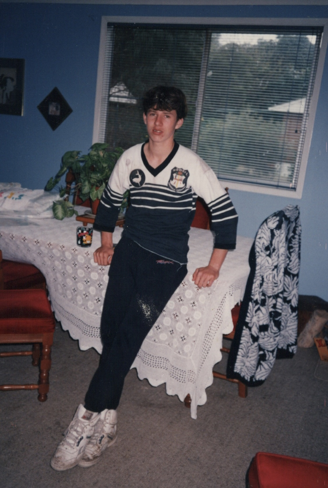 Adam in the dining room in his Cronulla Caringbah football jersey